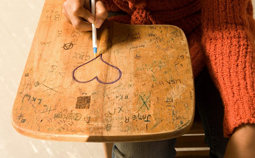 Student drawing a heart on her desk