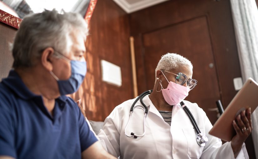 Doctor talking to senior male patient in a home visit