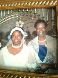 Two women at a wedding. One is wearing a wedding dress.