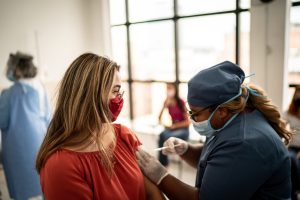 Community healthcare worker vaccinating a woman.