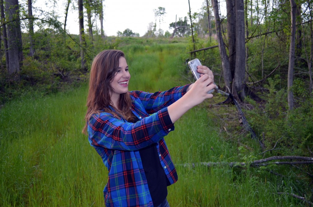 a girl taking a selfie with a cell phone