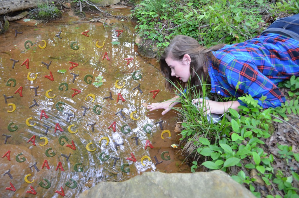 girl seeing a reflection in the water with DNA swimming in it