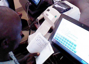 A health worker rapidly enters patient information into a touchscreen EMRS in Malawi.