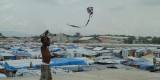 A child plays with a kite in a tent camp after the earthquake, Port-au-Prince, Haiti, 2010.