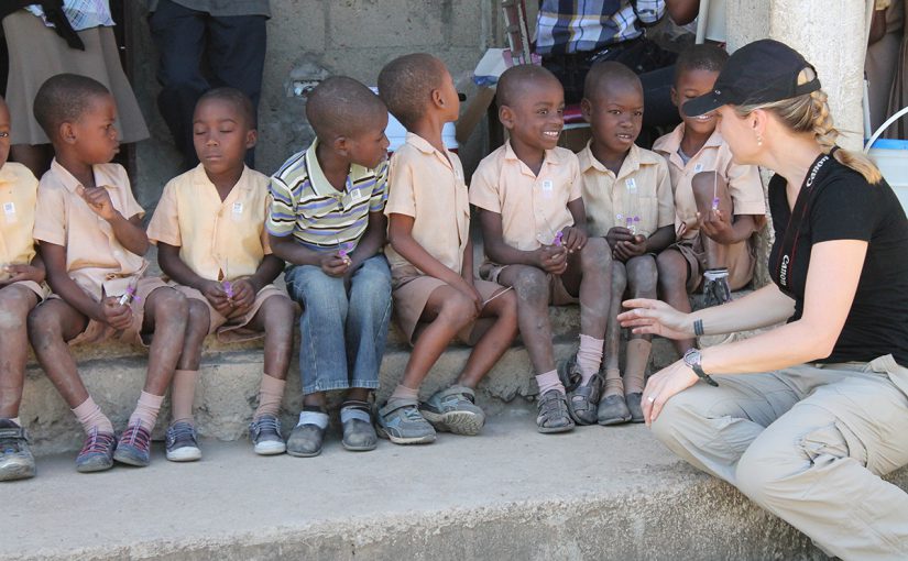 LT Knipes chats with school children who have been enrolled and are waiting to be tested for lymphatic filariasis and malaria in Nord Est Department, Haiti.