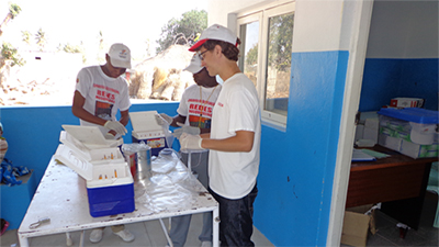 CDC epidemiologist Mateusz Plucinski (right) organizing dried blood spots collected during a household survey in Nampula, Mozambique in 2013 aimed at assessing the impact of a bed net distribution campaign on malaria and lymphatic filariasis exposure. Photo by Mateusz Plucinski/CDC.