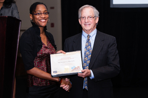 Monique Brown receives the first place student poster prize from NCHS Director Ed Sondik.