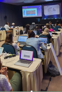 Photo of rows of attendees on laptops at a training session at the closing of Wiki4WorldHearindDay2023