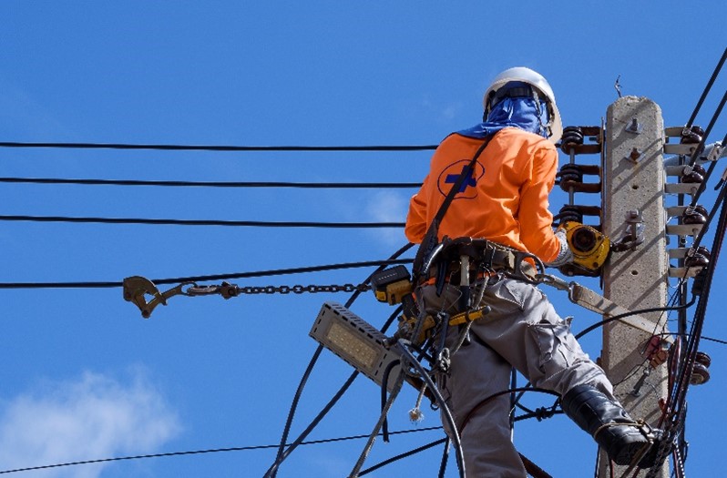 A single individual works alone atop power lines