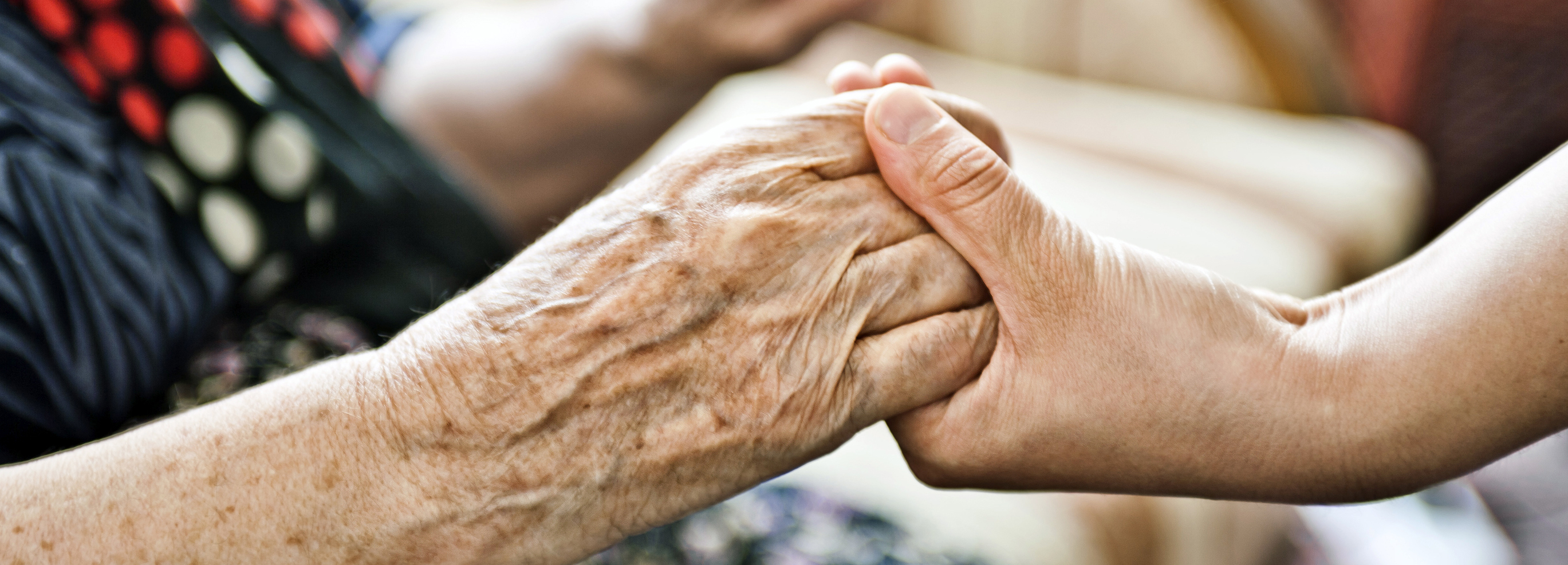 Younger adult holding older adult's hands