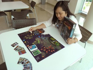 Sherline Lee looking over the board game Pandemic