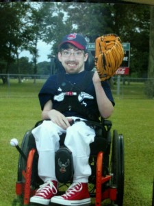 Zac posing in his wheel chair for his baseball team photo