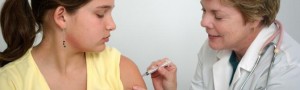 Girl receiving flu vaccine from female doctor