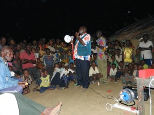 Community leader talking to villagers before a screening of the educational monkeypox video