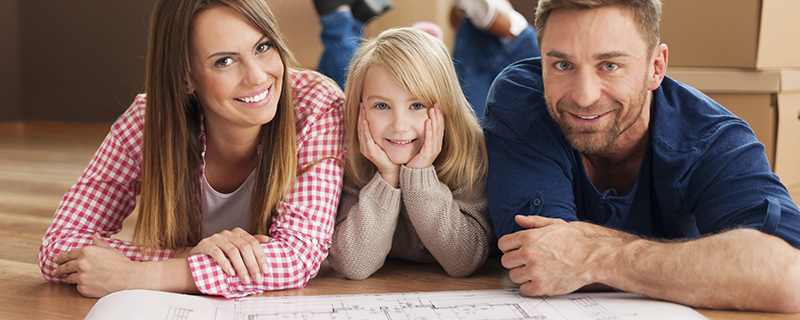 Mom, dad, and child with blueprints for house.