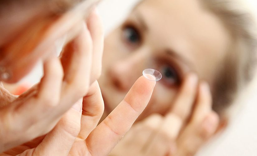 close up of a woman putting contact lens in her eye