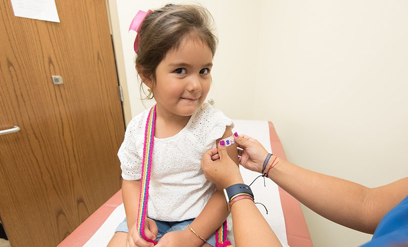 Little girl getting a bandaid.