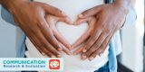 Black man holding belly of his pregnant wife making heart. Pregnant woman and loving husband hugging tummy at home. Heart of hands by multiethnic couple on pregnant belly.