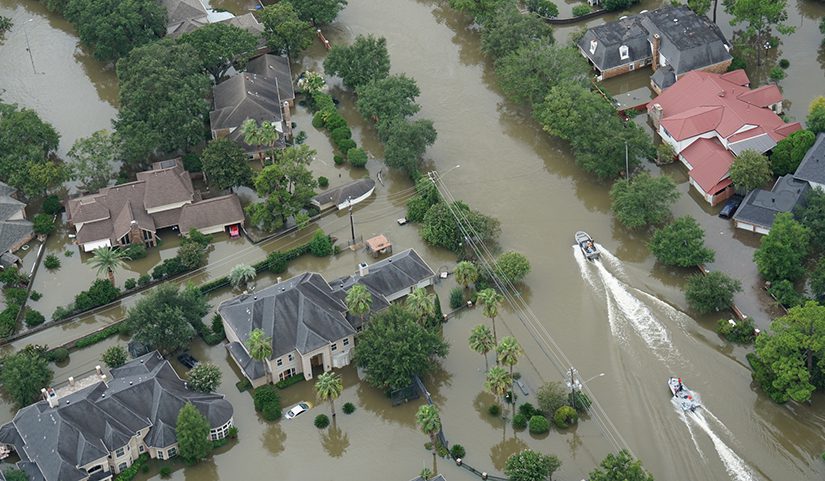 Two boats motor down a flooded residential street after Hurricane Harvey.