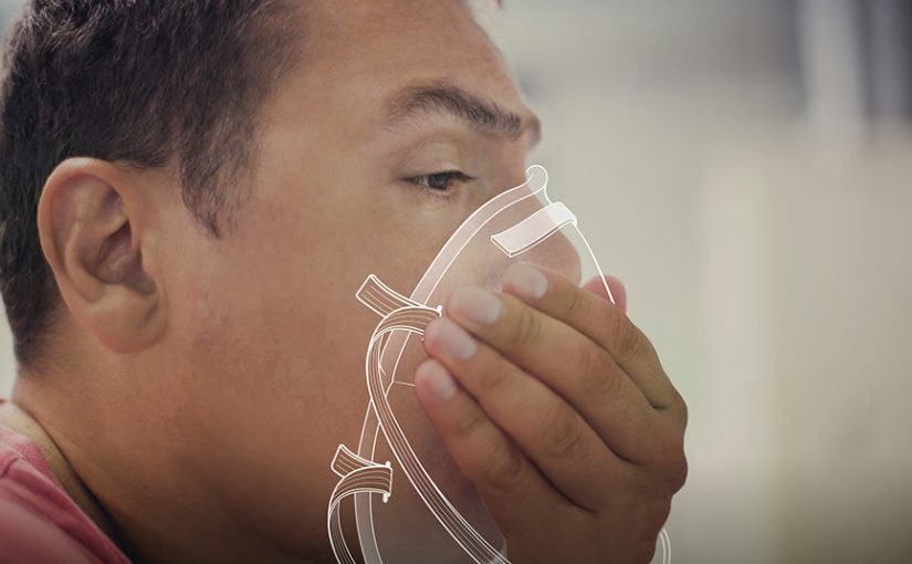 Close-up photo of a man putting on a respirator.