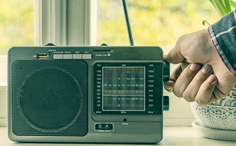 Hand turning knob on vintage radio