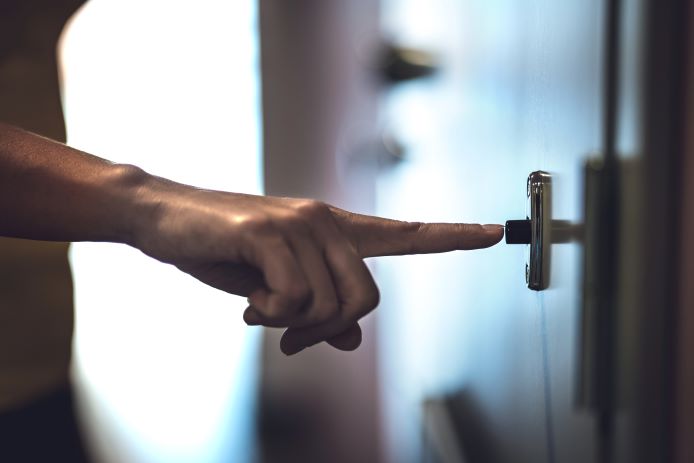 A person pushing a doorbell button.