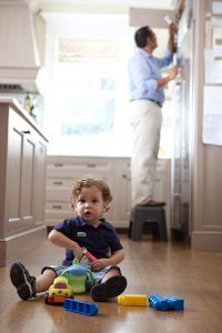 Toddler playing with father in the background