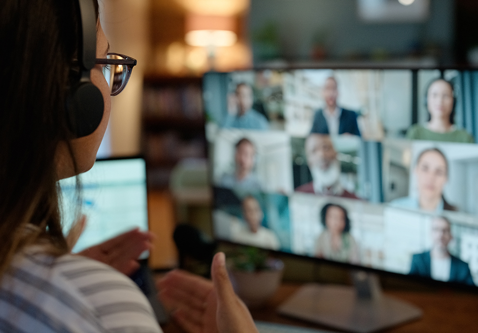 Virtual meeting attendee in front of computer screen showing other attendees.