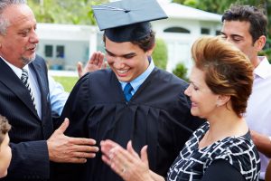 Hispanic Student And Family Celebrating Graduation Smiling