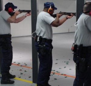 three men aiming guns in a firing range