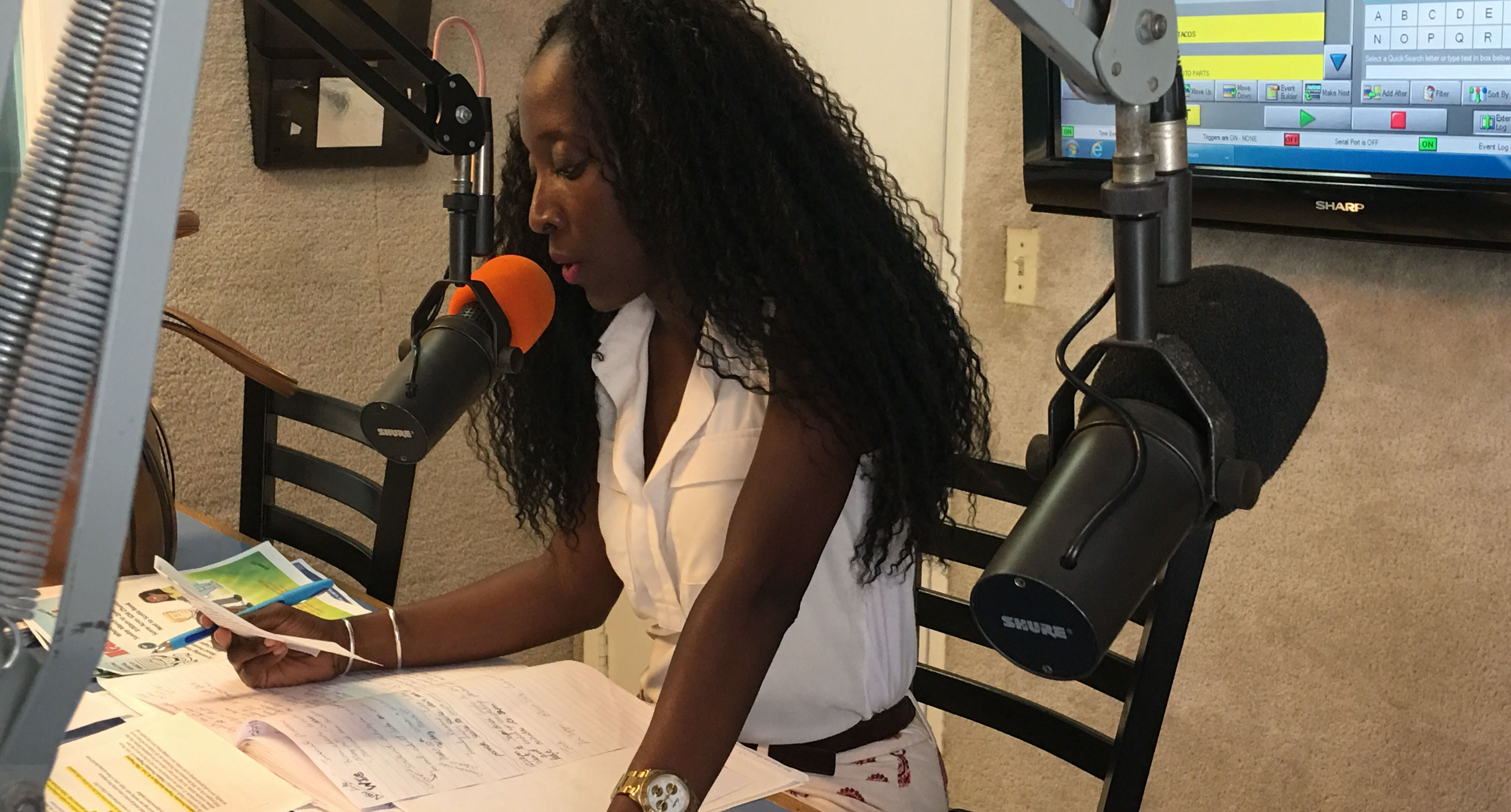 Nykole Tyson, Director of Public Relations for the US Virgin Islands Department of Health, speaking into a radio microphone.