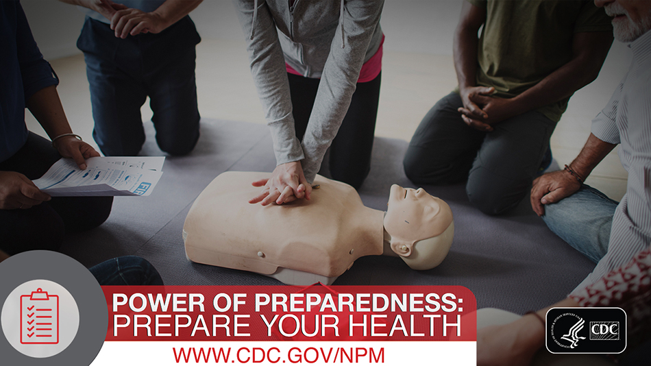 Group of people kneeling around a CPR dummy.