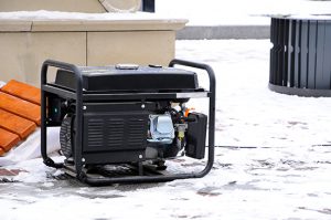 A portable generator sitting outside in the snow.