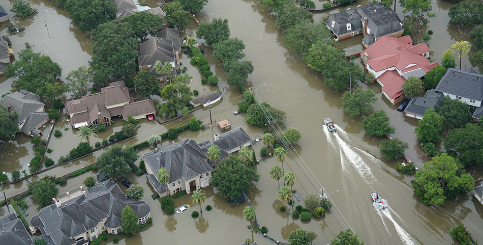 Two boats motor down a flooded residential street after Hurricane Harvey.