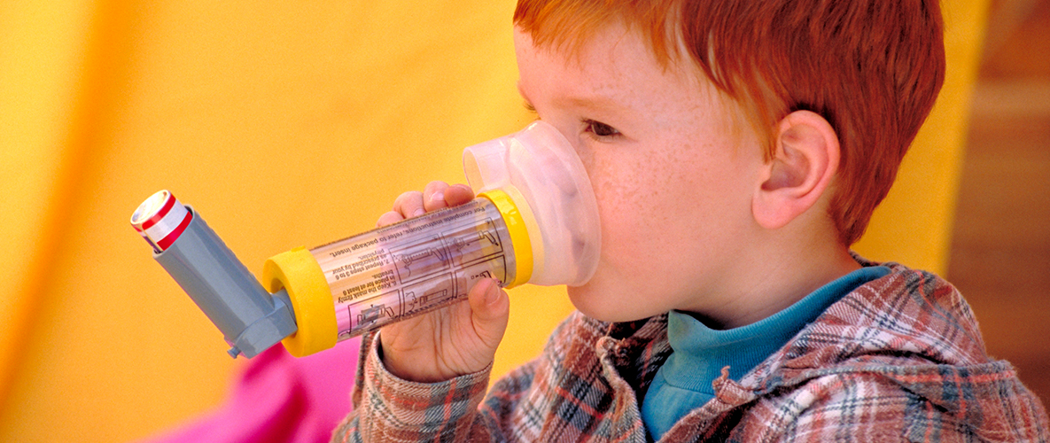 Little boy using a chamber to administer asthma medication