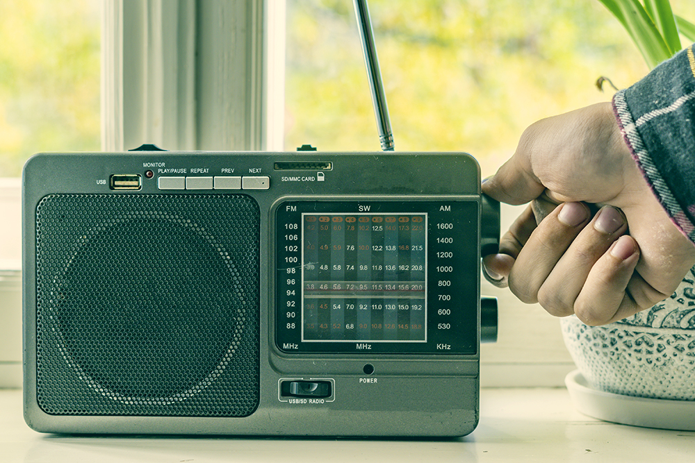 Hand turning knob on vintage radio