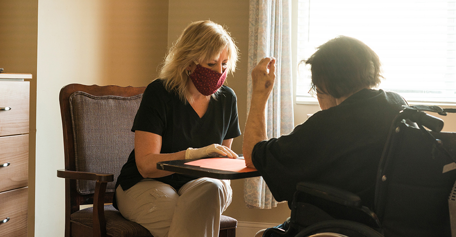 Stock photo of two women wearing masks during a home health visit.