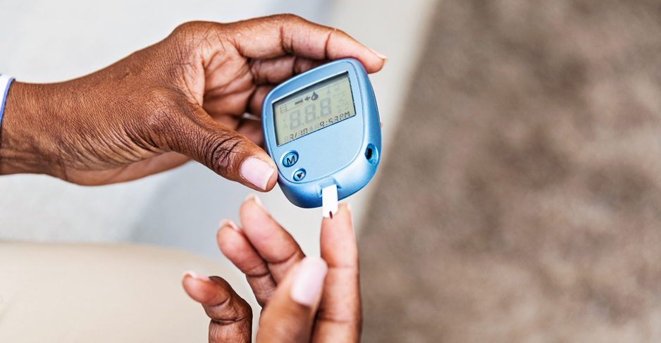 A woman tests her blood sugar using a blood glucose meter.