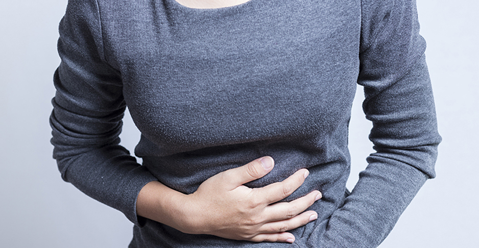 A woman with her hand on her stomach.