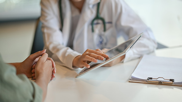 A picture of a doctor showing a patient radon information on a digital tablet.